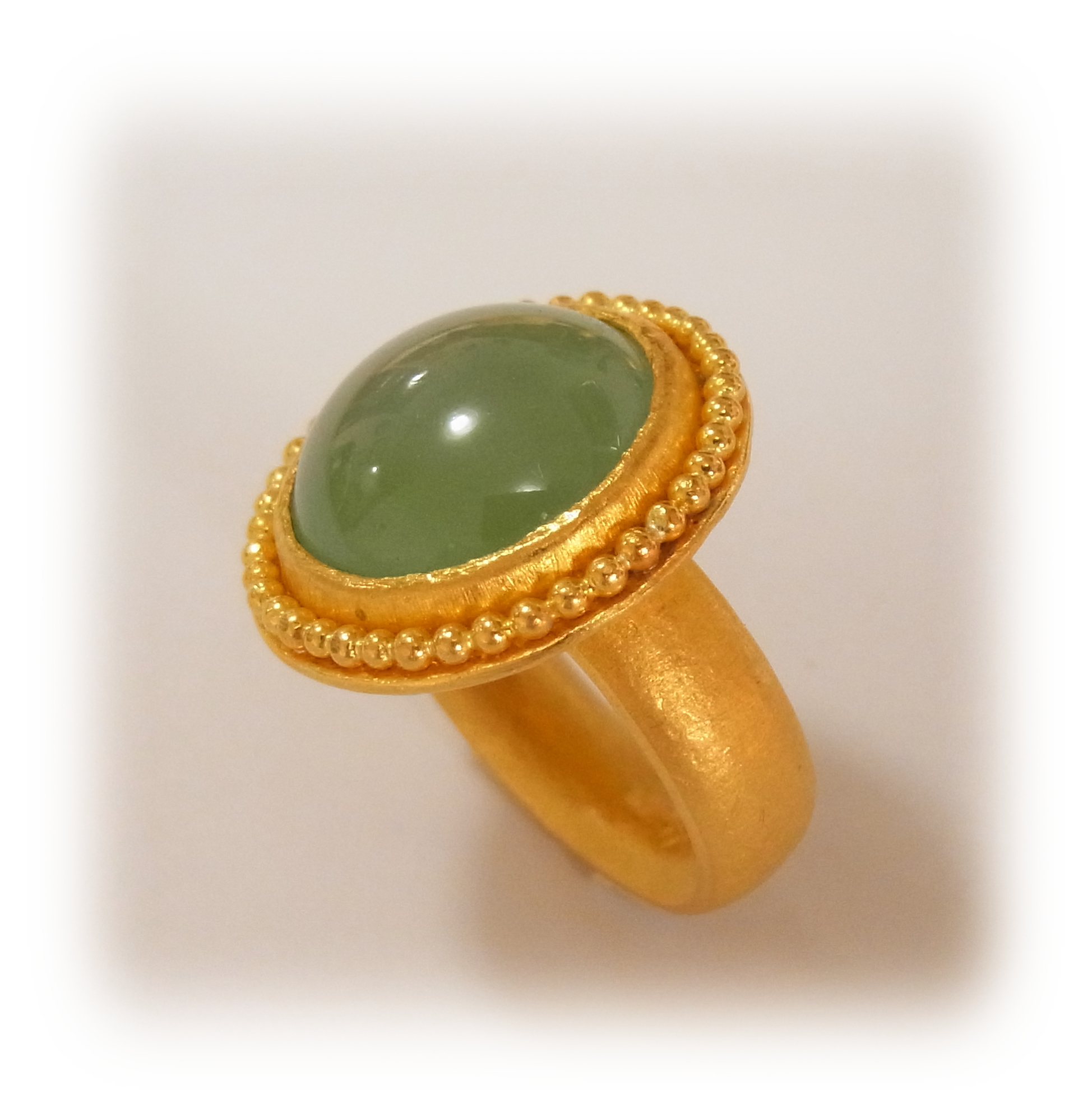 Round-cabochon green Jadeite ring with gold granulation (seen from the side)
