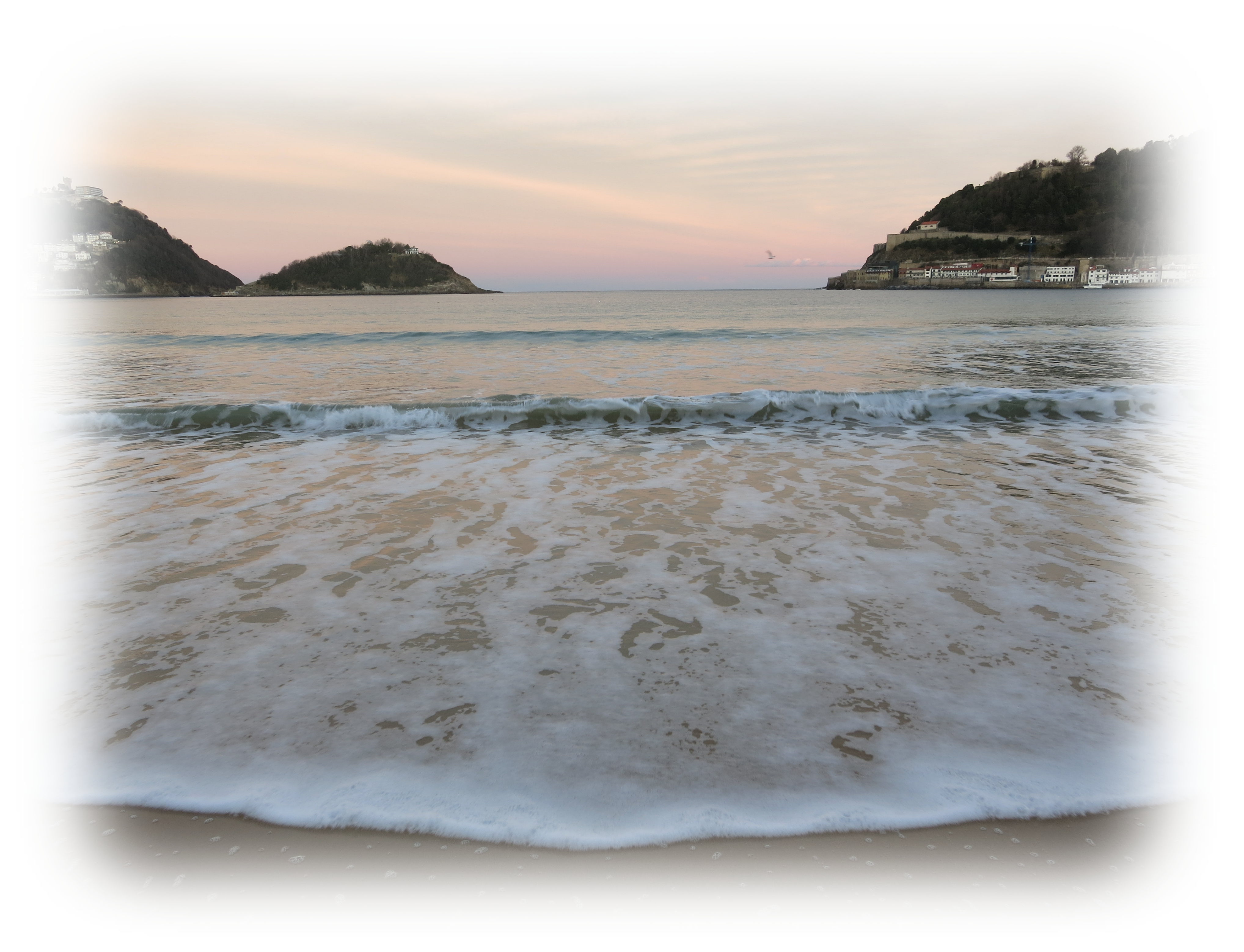 ラ・コンチャ湾の夕焼けの浜に寄せる波